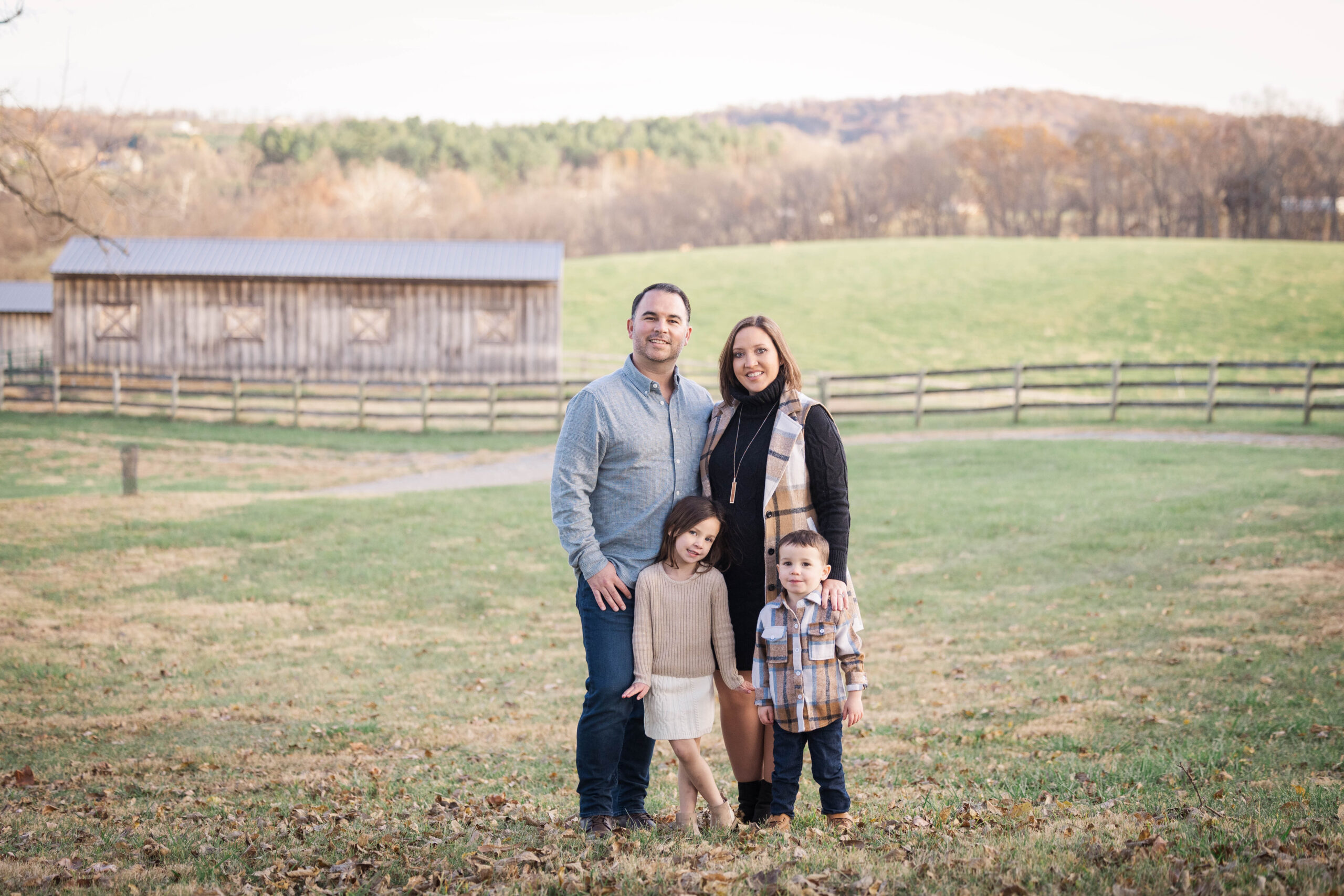 family portrait at a farm with rolling hills in the background