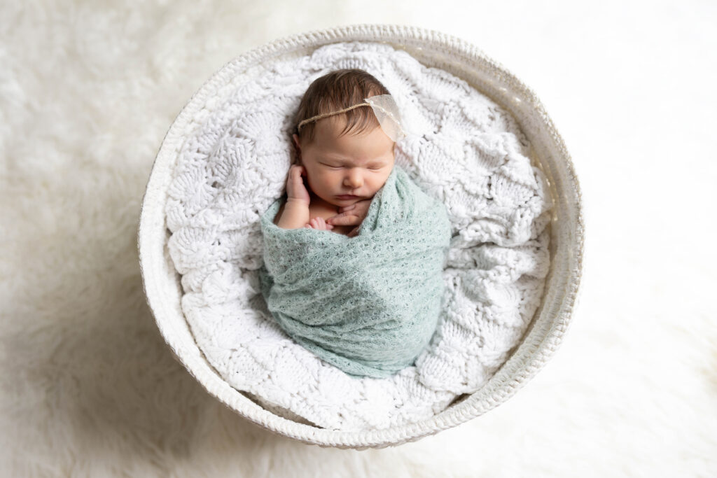 Big sisters jumping on the bed with newborn baby Taylor during an in-home lifestyle newborn photography session in Northern Virginia.