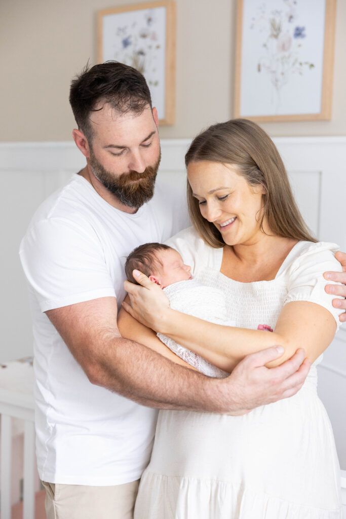 Big sisters jumping on the bed with newborn baby Taylor during an in-home lifestyle newborn photography session in Northern Virginia.