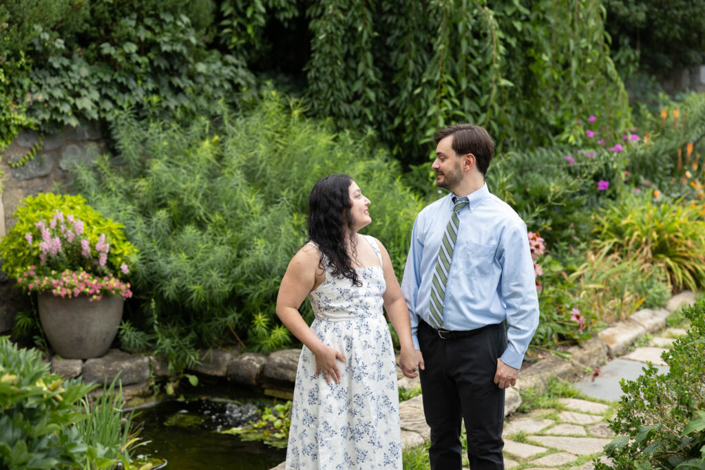 Engaged couple walking through Bishop's Garden at the Washington National Cathedral during a summer engagement photography session in Washington DC.